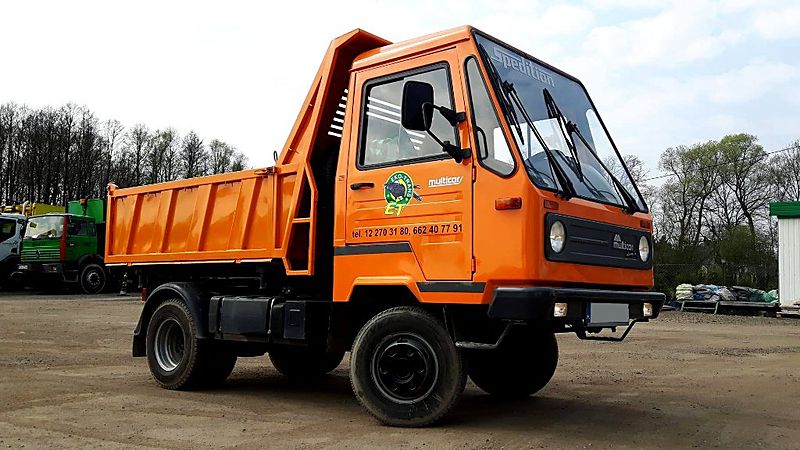 Pomarańczowy Multicar M26 z wywrotką, widok z boku